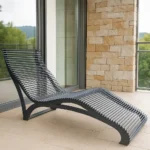 Metāla dārza šezlongs uz lodžijas pie akmens sienas