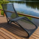 Metāla dārza šezlongs uz koka terases pie ezera