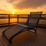 Metāla šezlongs uz terases saulrietā