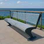 Metāla stienīšu sols uz promenādes pie jūras