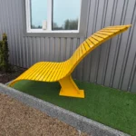 Dzeltenais viļņotais metāla sols sānskatā pie ēkas