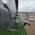 Metāla sols sānskatā pie industriālas ēkas sienas