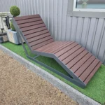 Metāla atpūtas sols ar koka sēdvirsmu pie ēkas