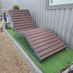 Metāla atpūtas sols ar koka dēļiem pie ēkas, tuvplāns